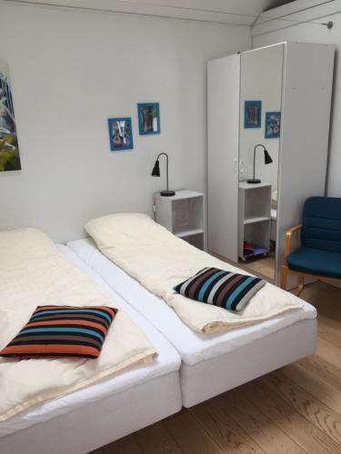 RisskovBB-Risskov的一间卧室配有两张床和一张蓝色椅子