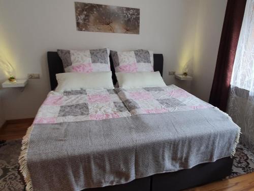欣特察尔滕Ferienwohnung Hitz的一张床上有粉红色和灰色的被子