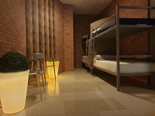 圣地亚哥－德孔波斯特拉albergue SANTO SANTIAGO的带双层床和砖墙的客房