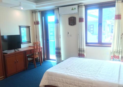 海防Thien Anh Hotel的一间卧室配有一张床、一张书桌和一台电视