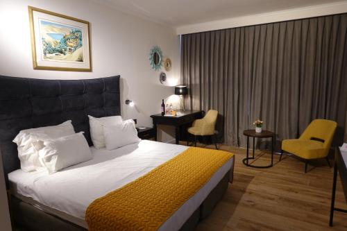 拿撒勒拿撒勒广场伊利特酒店 的酒店客房带一张床、一张桌子和椅子