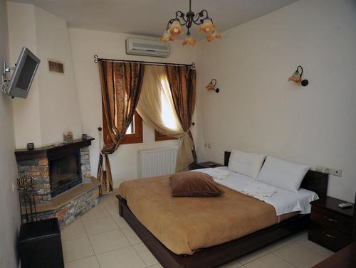 Psarádes友谊旅馆的一间卧室设有一张大床和一个壁炉