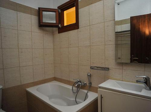 Psarádes友谊旅馆的带浴缸和盥洗盆的浴室