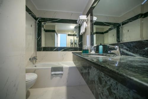 科孚镇码头城市酒店的一间带水槽、卫生间和镜子的浴室