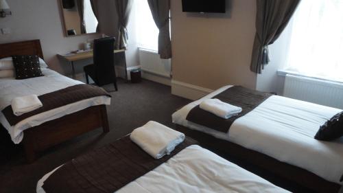 格拉斯哥Sandyford Lodge的酒店客房配有两张床和一张书桌