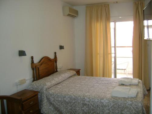 诺韦尔达航道公寓旅馆的一间卧室设有一张床和一个窗口