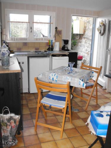 罗什福尔Maisonnette Mimi的厨房配有桌子、两把椅子和一张桌子