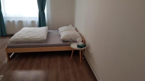 德辛Apartmán Pod Zámkem的一张小床,位于带边桌的房间里