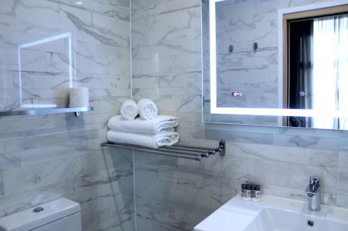 伦敦NOX Paddington的浴室配有盥洗盆、镜子和毛巾