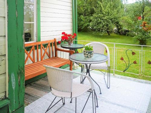 Tingsryd5 person holiday home in TINGSRYD的庭院配有两把椅子、一张桌子和一张长凳