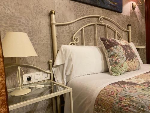 巴塞罗那奥尔良旅馆的一间卧室配有一张床和一个带灯的玻璃桌