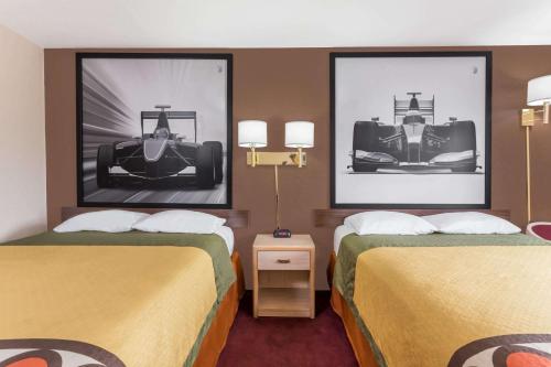 雪尔顿谢尔顿速8酒店 的配有汽车照片的酒店客房的两张床