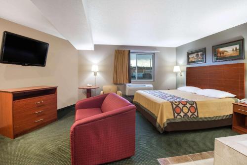 克利尔菲尔德速8克利尔菲尔德酒店的配有一张床和一把椅子的酒店客房