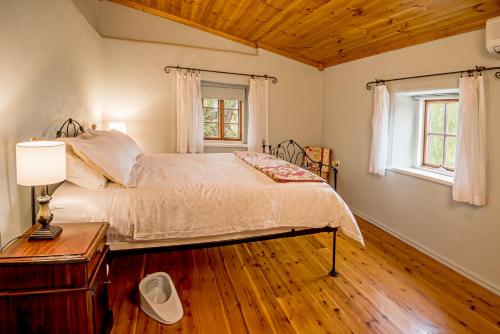 MaranangaLucy's Cottage的一间卧室设有一张大床,铺有木地板