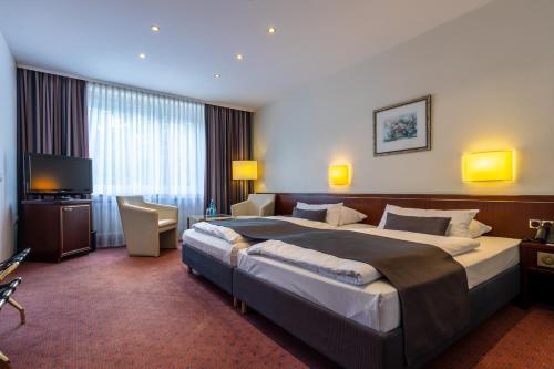 杜塞尔多夫Trip Inn Hotel Esplanade的酒店客房设有一张大床和一台电视。