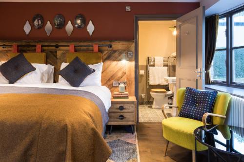 牛顿阿伯特Dartmoor Halfway Inn的配有一张床和一把椅子的酒店客房