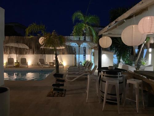 马贝拉Casa Holandaluzas Marbella near Beach, with salt water Pool and private parking的一个带椅子和遮阳伞的游泳池的度假酒店