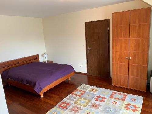 弗瓦迪斯瓦沃沃Korab 2的一间卧室配有一张床、木制橱柜和地毯。