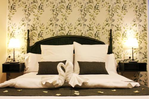 萨比奥特Hotel Rural Molino del Albaicín的一间卧室配有一张带白色枕头的床和两盏灯。