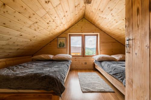 沃乌科维亚Chaty Jak Dawniej的配有窗户的小木屋内的两张床