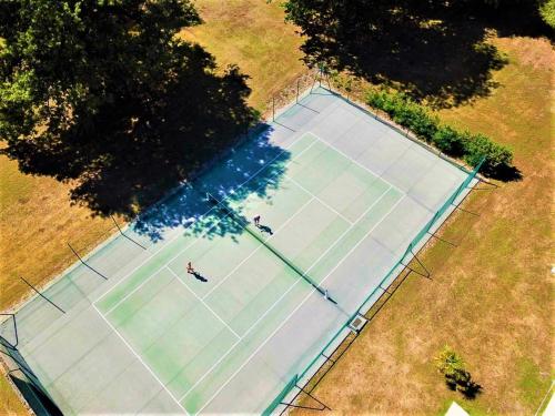 Le Boulay-MorinChâteau du Boulay Morin的网球场的顶部景观,上面有两个人