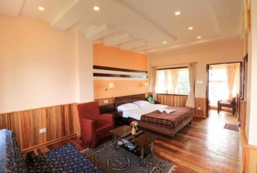 大吉岭Darjeeling Tourist Lodge的酒店客房,配有床和沙发