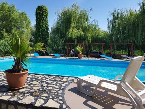 穆里吉奥尔三角洲天堂度假酒店的游泳池旁的白色椅子