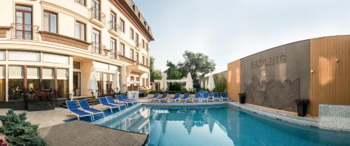 敖德萨Redling Hotel的一座带蓝色椅子的游泳池和一座建筑