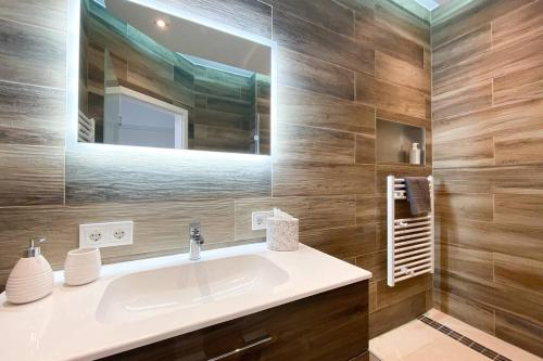 莱比锡Luxus-Apartment in Leipzig mit Privat-Parkplatz的一间带水槽和镜子的浴室