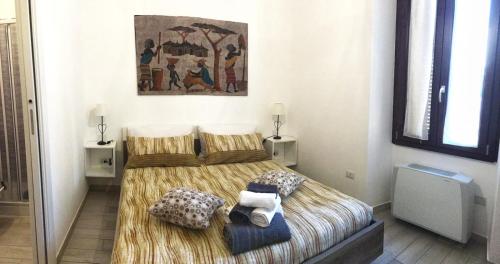 阿尔盖罗B&B MaryGrace的卧室配有一张床,墙上挂有绘画作品