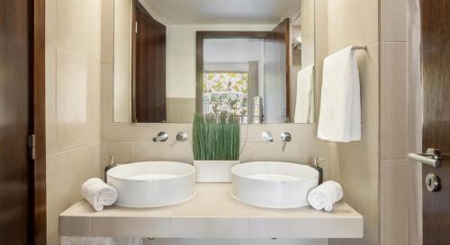 吉亚Novo Apartamento T2 Herdade dos Salgados - Vila das Lagoas的浴室设有2个白色水槽和镜子