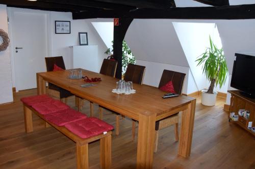 RüthenHaus Buuck - Herberge的木制用餐室配有桌椅和电视