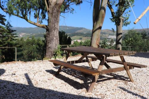 CadavalMoinho da Amélia的一张木餐桌,坐在砾石上