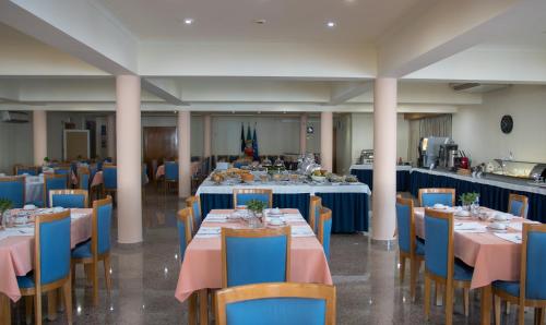 韦拉斯Hotel Sao Jorge Garden的宴会厅配有蓝色的桌子和蓝色的椅子