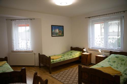 赖曼瑙-兹德鲁伊Dom Pod Lipą的一间卧室设有两张床和两个窗户。