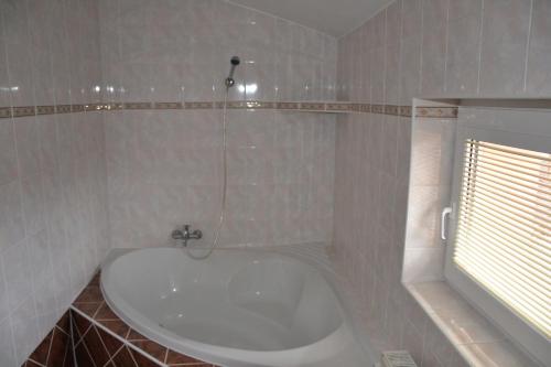什特尔巴查露普卡民宿的带窗户的浴室内的白色浴缸