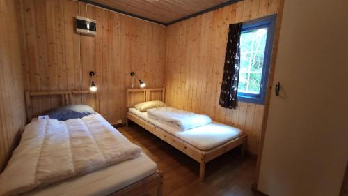BirkenesSolheim. Hytte med 2 soverom的配有木墙和窗户的客房内的两张床