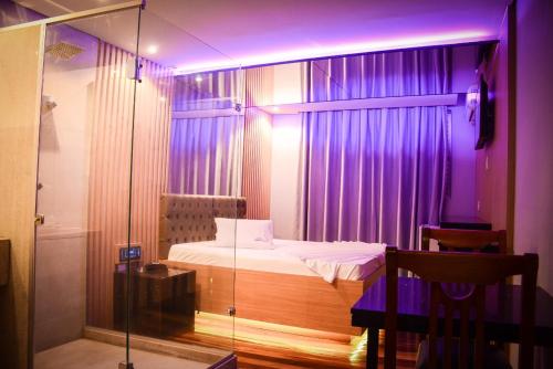 孔塔任Motel Sunny Day Contagem的一间卧室配有一张紫色灯床