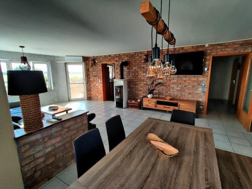 胡根尔舍姆Loft Unterkunft in Hügelsheim的厨房以及带木桌和椅子的用餐室。