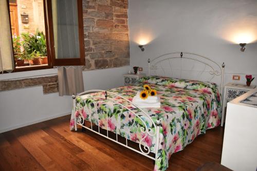 斯佩洛Borgo San Sisto Apartment的一间卧室配有一张带花卉床罩的床