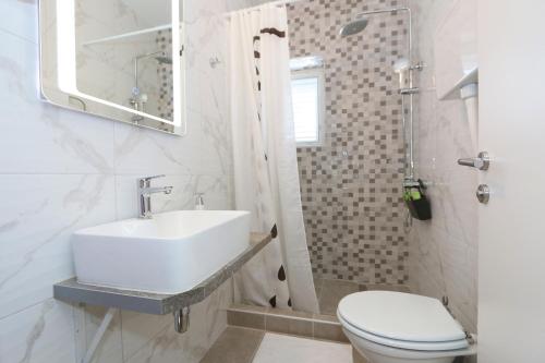 伦Rooms Bambina的白色的浴室设有水槽和卫生间。