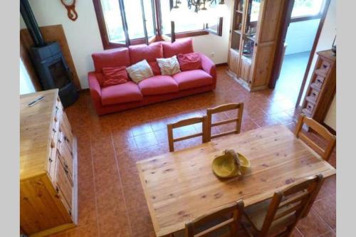 BerangaCHALET FAMILIAS 10 Huéspedes Beranga Noja Playas, Mascotas bienvenidas的客厅配有红色的沙发和木桌