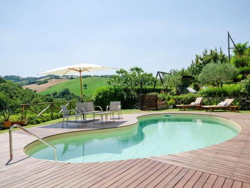 乌尔比诺Belvilla by OYO Villa Angolo Fiorito的木制甲板上的游泳池配有椅子和遮阳伞