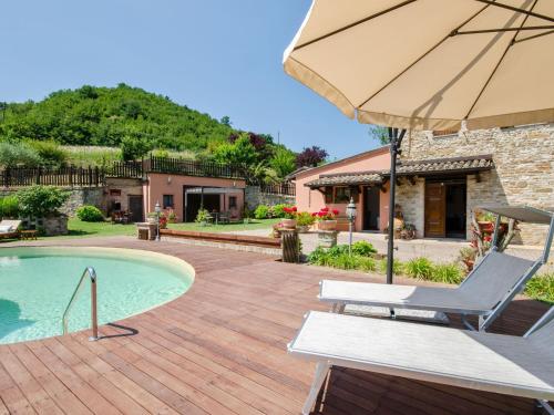 乌尔比诺Belvilla by OYO Villa Angolo Fiorito的一个带椅子和遮阳伞的庭院和一个游泳池