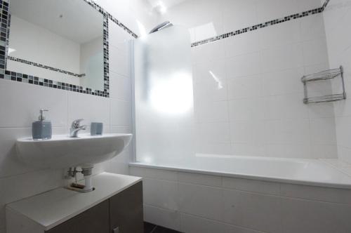 吕克瑟伊莱班F2 Aux pieds des Thermes 3 étoiles的白色的浴室设有水槽和浴缸。
