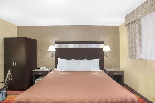 北卑尔根北卑尔根豪生快捷酒店的酒店客房带一张橙色床罩