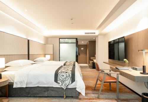 深圳深圳东门中泰来大酒店的一间卧室配有一张床、一张书桌和一台电视