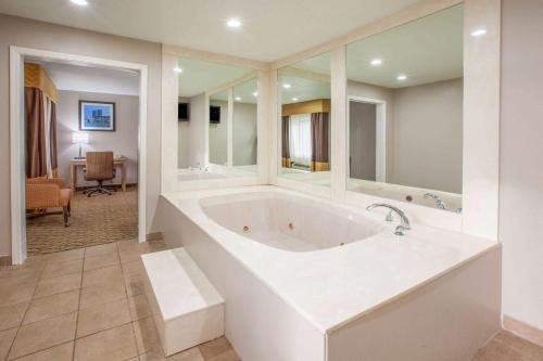大急流城大急流城机场贝蒙特旅馆套房酒店的一间大型的白色浴室,内配浴缸,还有一间客房