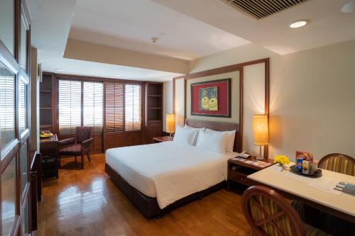 曼谷素坤逸通罗中心站酒店的酒店客房配有一张床、一张书桌和一张书桌。