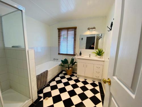 土乌巴Ashbrooke Cottage的浴室铺有黑白格子地板。